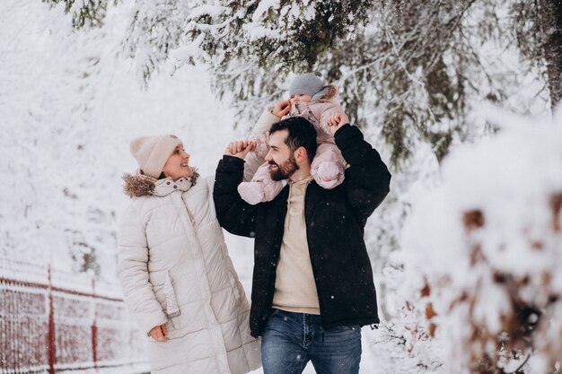 Junge Familie mit kleiner Tochter in einem Winterwald voll des Schnees