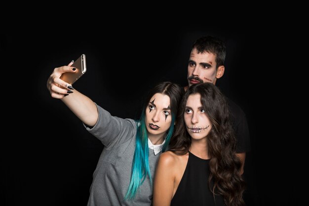 Junge Firma mit dem gruseligen Make-up, das selfie nimmt
