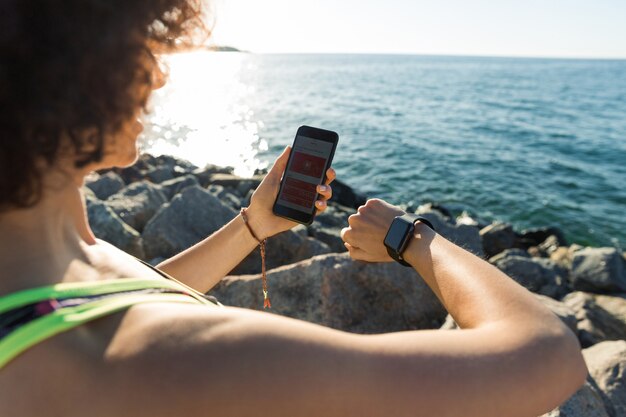 Junge Fitnessfrau, die ihre Smartwatch aufstellt