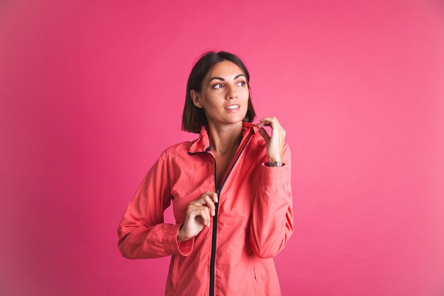 Junge fitte Frau in Sportbekleidungsjacke auf Rosa