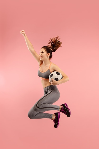 Junge Frau als Fußballfußballspieler springend