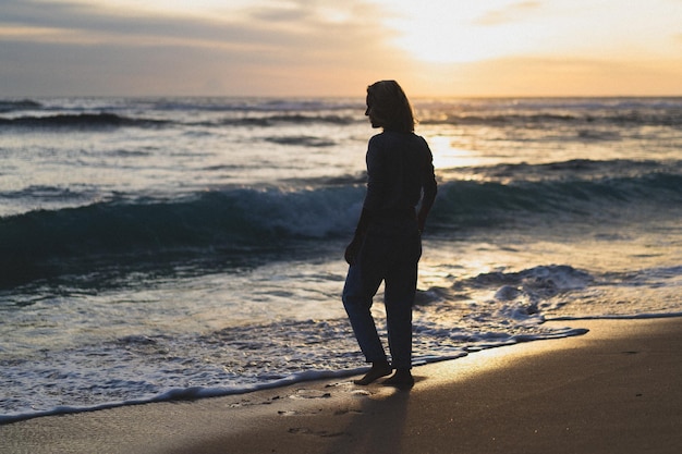 Junge Frau am Meer bei Sonnenuntergang.