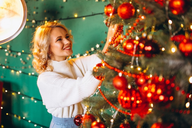 Junge Frau am Weihnachtsbaum zu Weihnachten