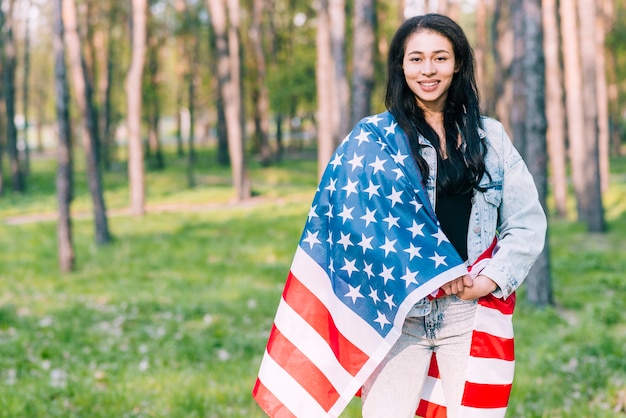 Junge Frau bedeckt mit Flagge von USA