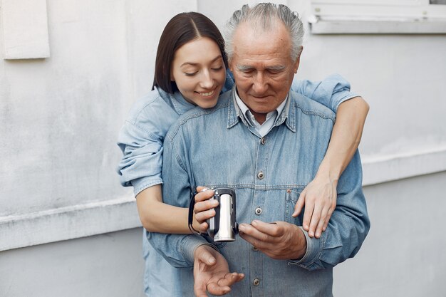 Junge Frau bringt ihrem Großvater bei, wie man eine Kamera benutzt