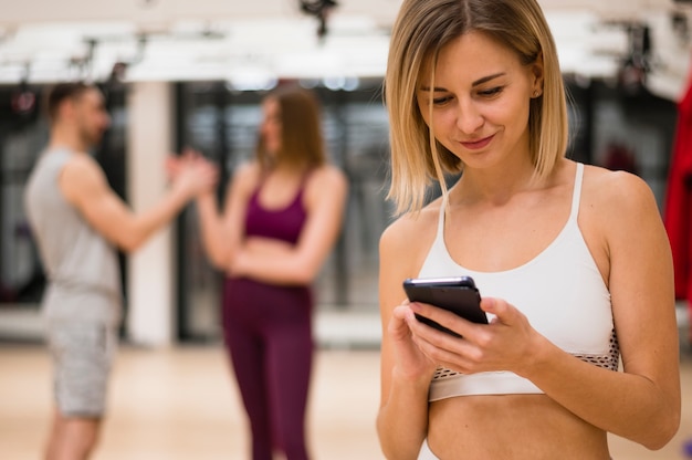 Kostenloses Foto junge frau der nahaufnahme, die ihr telefon überprüft