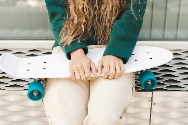 Kostenloses Foto junge frau der nahaufnahme mit skateboard