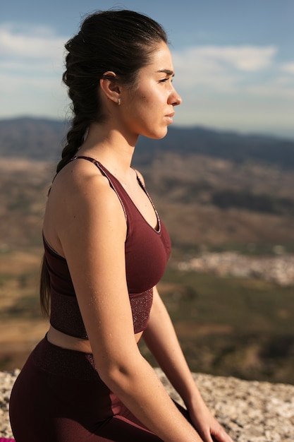 Junge Frau der Seitenansicht auf der Matte, die Yoga tut