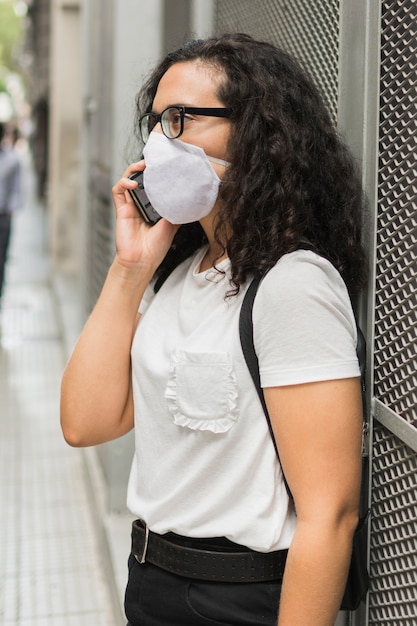 Junge Frau der Seitenansicht, die eine medizinische Maske trägt