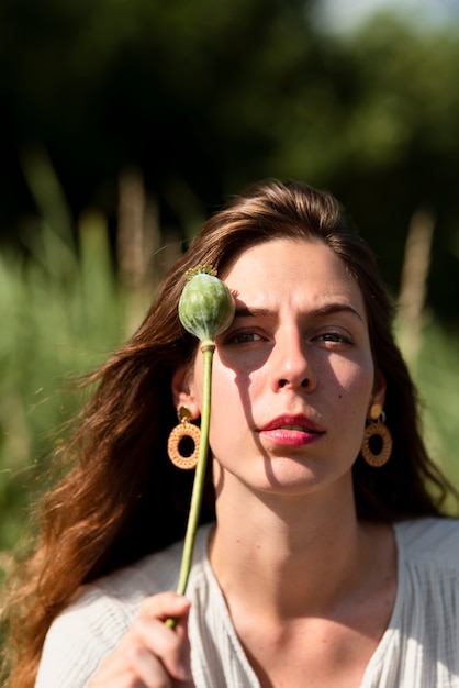 Kostenloses Foto junge frau der vorderansicht, die blume hält