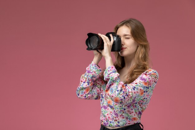 Junge Frau der Vorderansicht, die ein Foto mit ihrer Fotokamera macht