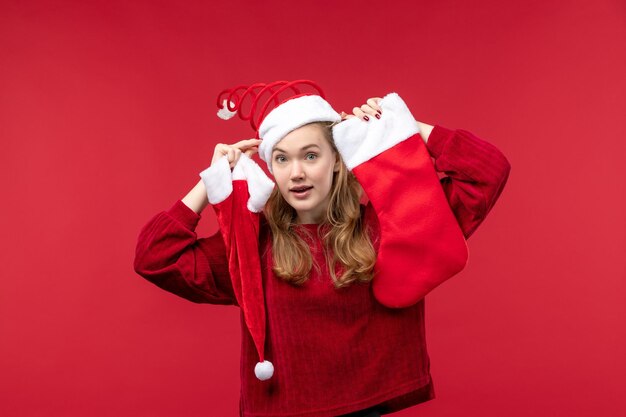 Junge Frau der Vorderansicht, die große Socke und Kappe, Feiertagsweihnachten hält