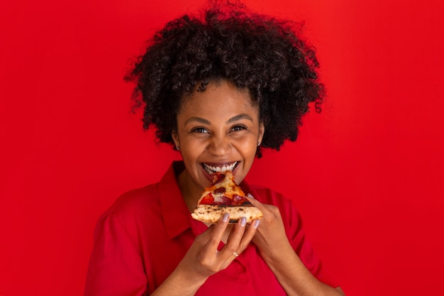 Junge Frau der Vorderansicht, die köstliche Pizza isst