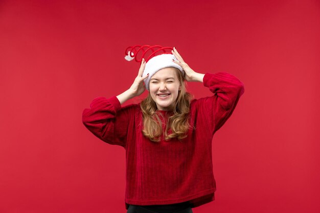 Junge Frau der Vorderansicht, die rote Weihnachtsmannmütze trägt, Feiertagsweihnachten