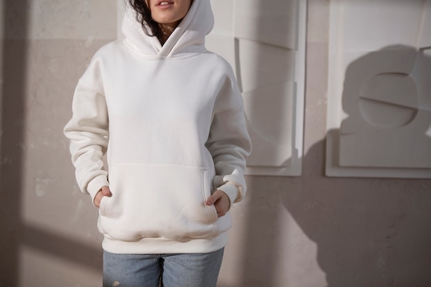 Junge Frau der Vorderansicht, die weißen Hoodie trägt