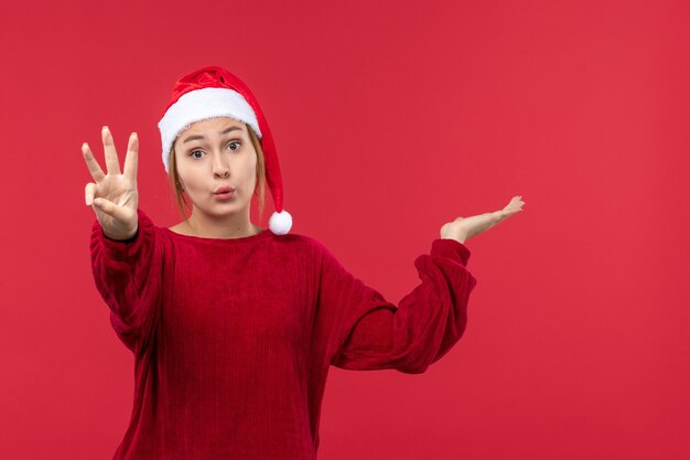 Junge Frau der Vorderansicht, die Zahl, rotes Feiertagsweihnachten zeigt