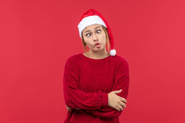 Junge Frau der Vorderansicht mit lustigem Ausdruck, rotes Feiertagsweihnachten