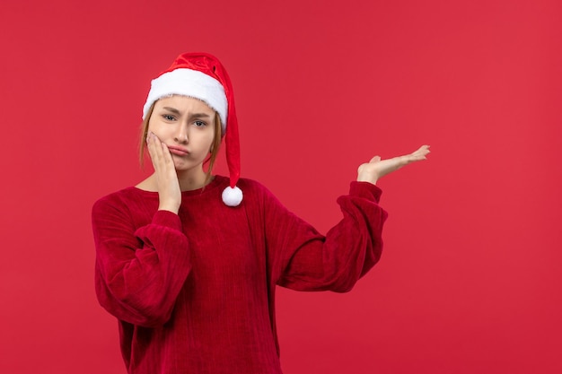 Junge Frau der Vorderansicht mit verwirrtem Ausdruck, rotes Feiertagsweihnachten
