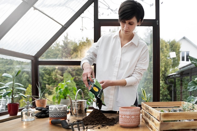 Junge Frau des mittleren Schusses mit Blumenerdebeutel