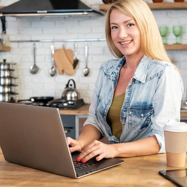 Junge Frau des smiley, die an einem Laptop arbeitet