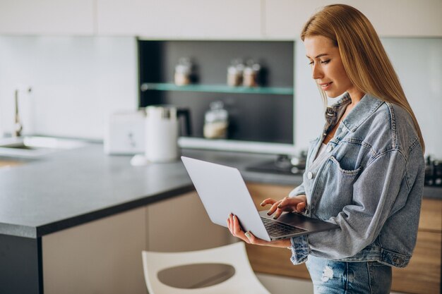 Junge Frau, die am Computer von zu Hause aus arbeitet