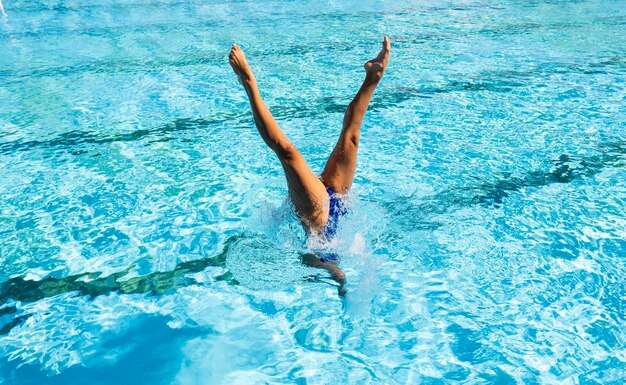 Junge Frau, die am Schwimmbad aufwirft