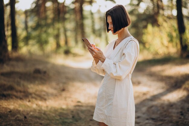 Junge Frau, die am Telefon im Park spricht