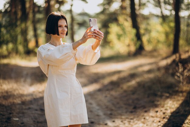 Junge Frau, die am Telefon im Park spricht