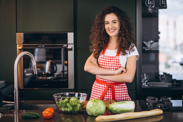 Junge Frau, die an der Küche kocht