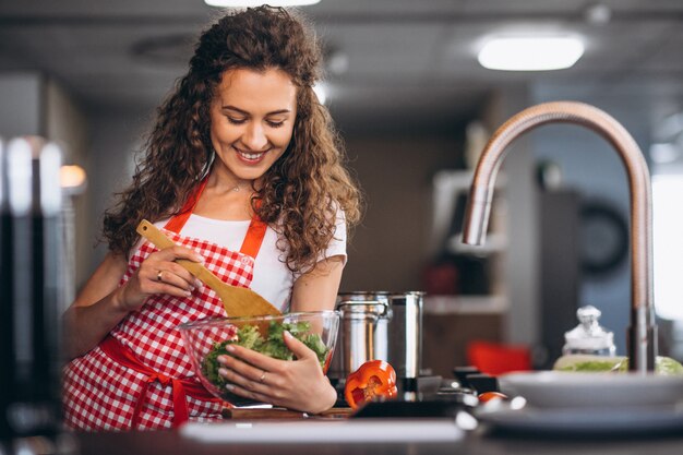 Junge Frau, die an der Küche kocht