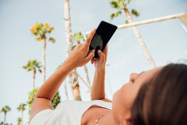 Kostenloses Foto junge frau, die an ihrem telefon grast