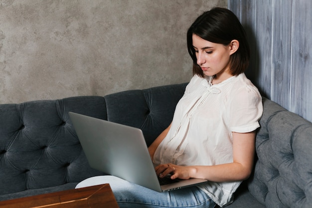 Kostenloses Foto junge frau, die an laptop arbeitet