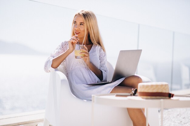 Junge Frau, die an Laptop auf Ferien arbeitet