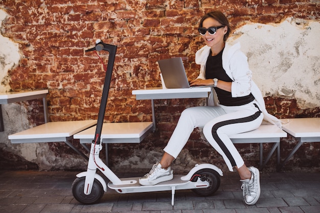 Junge Frau, die an Laptop in einem Café arbeitet