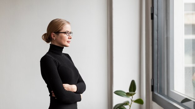 Junge Frau, die auf Fenster schaut