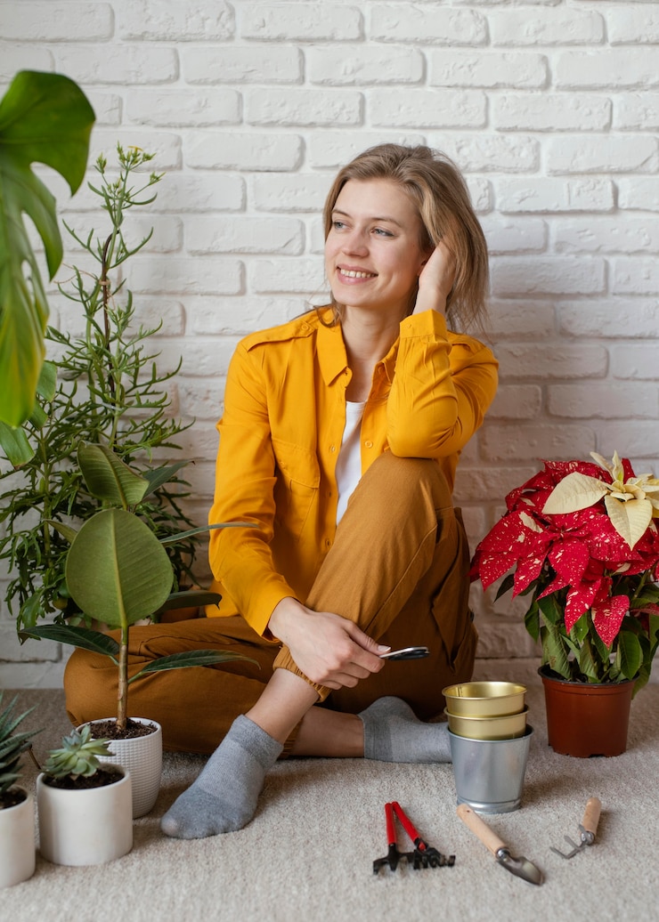 Kostenlose Foto junge frau, die auf ihrem hausgartenboden sitzt