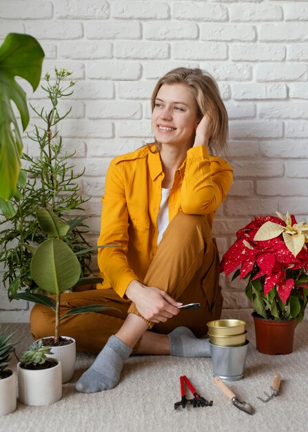 Junge Frau, die auf ihrem Hausgartenboden sitzt