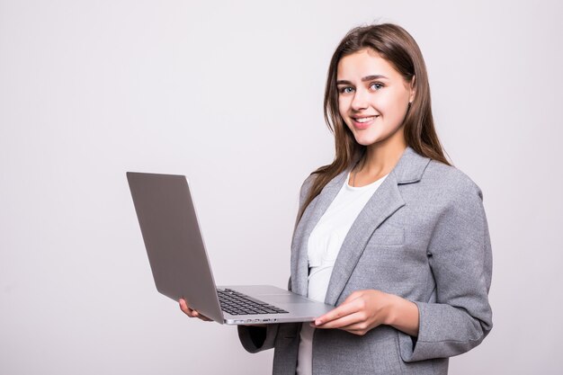 Junge Frau, die auf Laptop lokalisiert auf weißem Hintergrund arbeitet