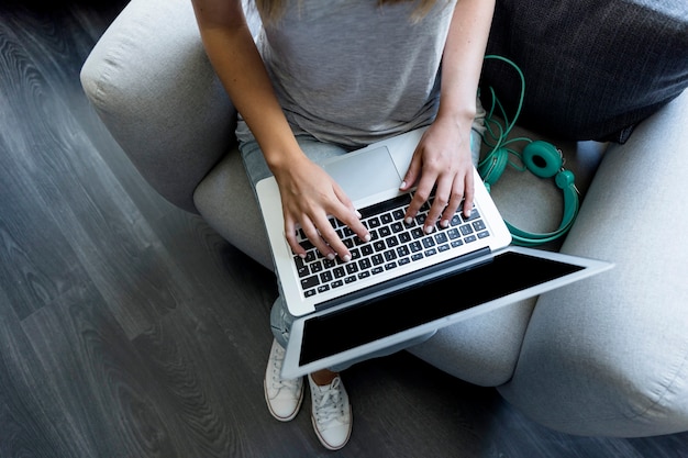 Junge Frau, die auf Laptop schreibt