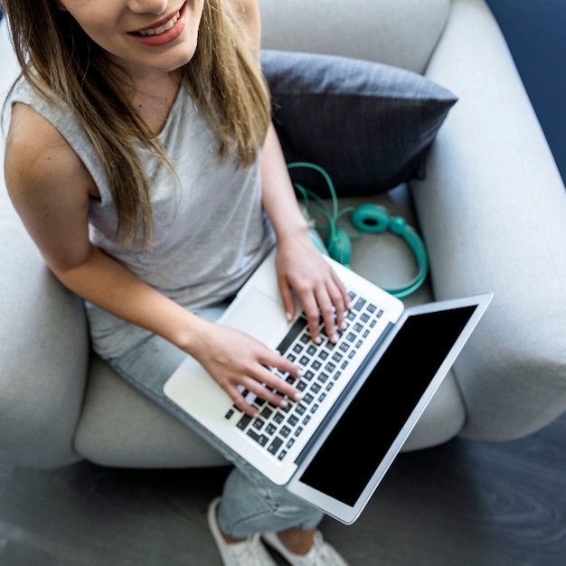 Kostenloses Foto junge frau, die auf laptop schreibt