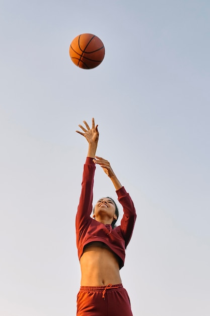 Junge frau, die basketball spielt