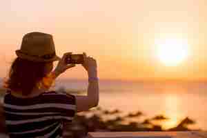 Kostenloses Foto junge frau, die bild von meer sonnenaufgang