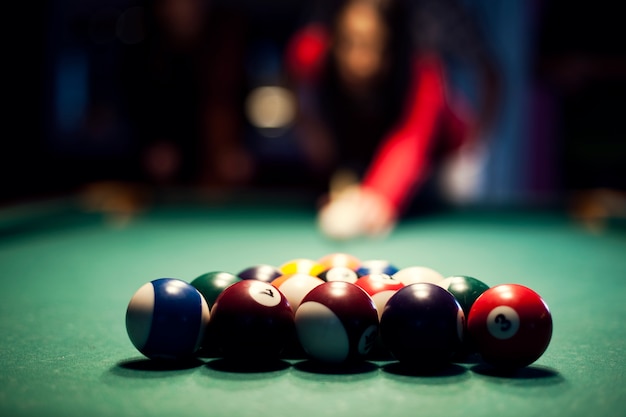 Junge frau, die billard spielt