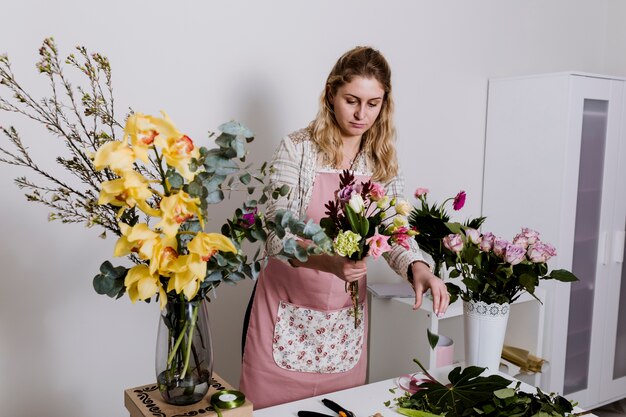 Junge Frau, die Blumen für Bündel nimmt