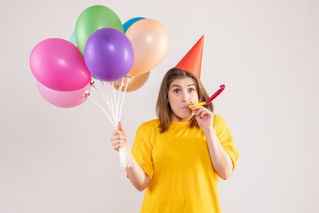 junge Frau, die bunte Luftballons auf Weiß hält