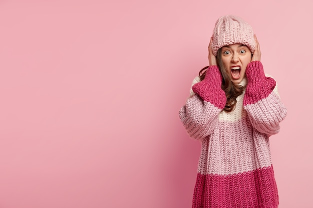 Junge Frau, die bunte Winterkleidung trägt