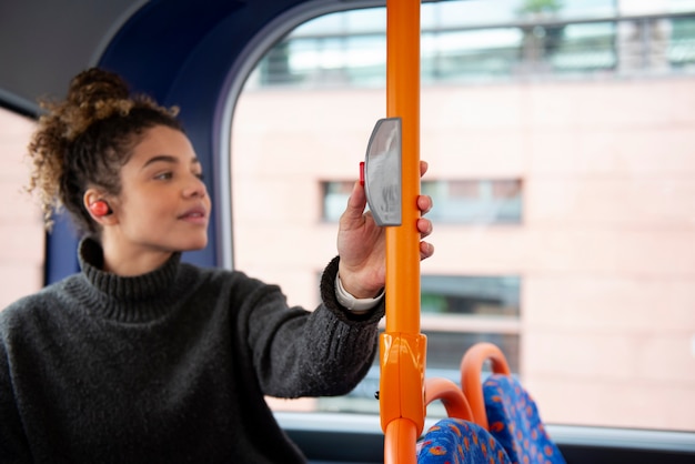 Kostenloses Foto junge frau, die den bus in der stadt anhält