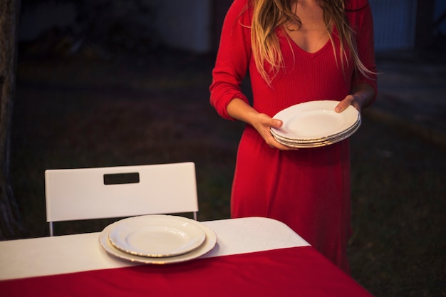 Junge Frau, die die Tabelle für Weihnachtsabendessen einstellt