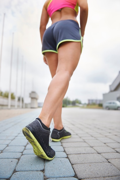 Junge Frau, die draußen trainiert. Menschliche Beine vor einem harten Training