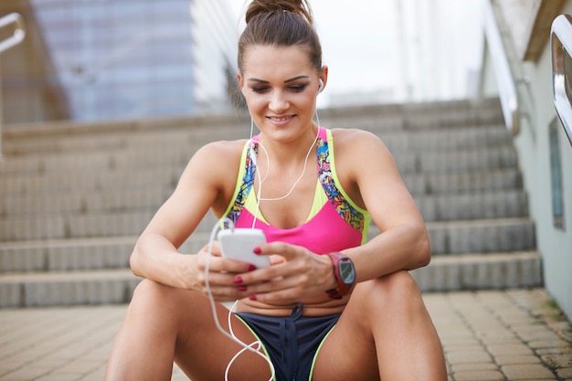 Junge frau, die draußen trainiert. musik hilft mir, den rhythmus beim joggen zu halten